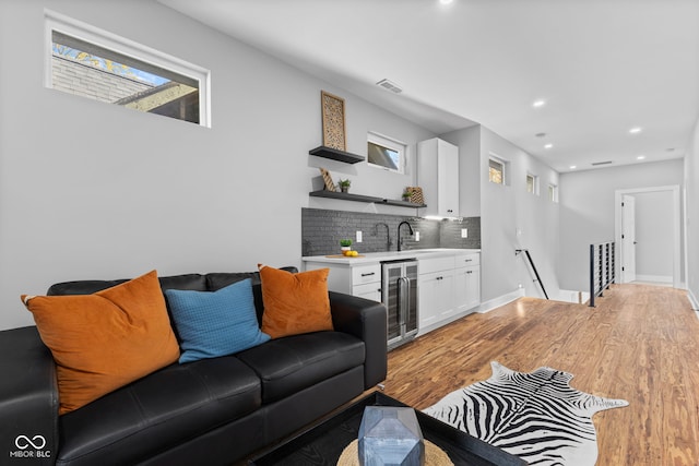 1514 E 12th St, Indianapolis, IN 46201 - living area featuring beverage cooler, wet bar, light wood-type flooring, recessed lighting, and plenty of natural light