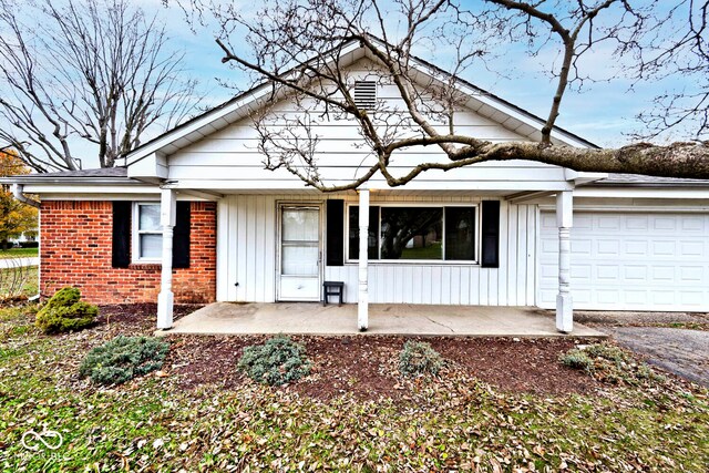 single story home featuring a porch and a garage