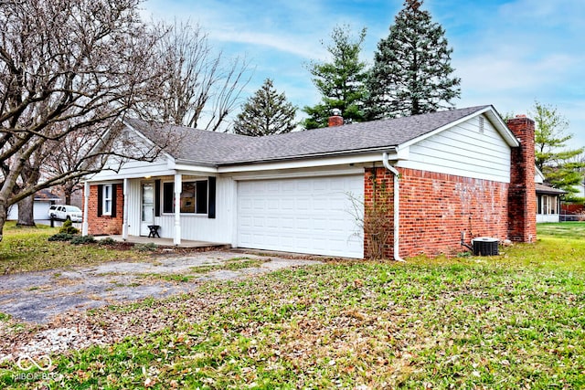 single story home with central AC unit and a garage