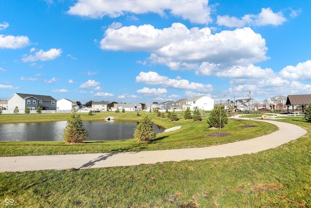 surrounding community featuring a water view and a lawn