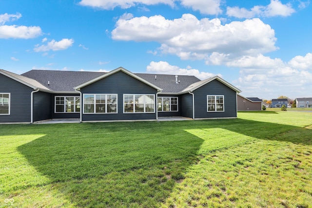 rear view of property featuring a patio and a yard