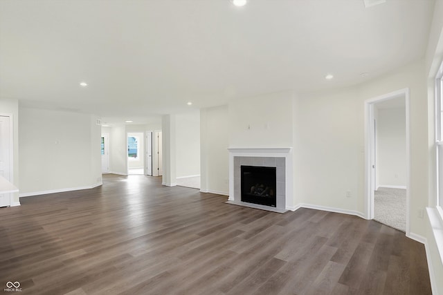 unfurnished living room with dark hardwood / wood-style flooring and a tile fireplace