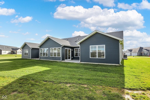 back of property with central air condition unit, a lawn, and a patio