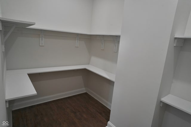 walk in closet with dark wood-type flooring