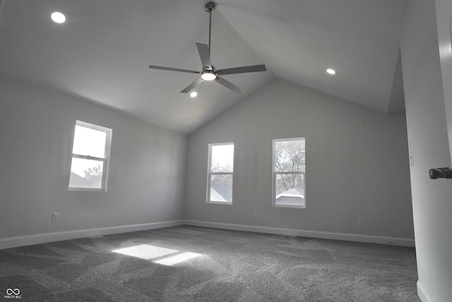 carpeted spare room with ceiling fan, plenty of natural light, and vaulted ceiling