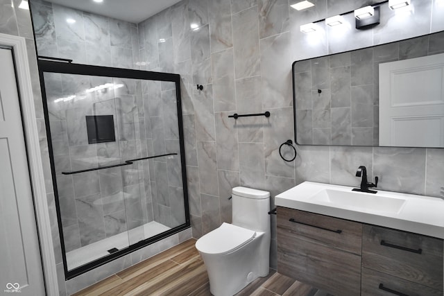 bathroom featuring an enclosed shower, vanity, toilet, and tile walls