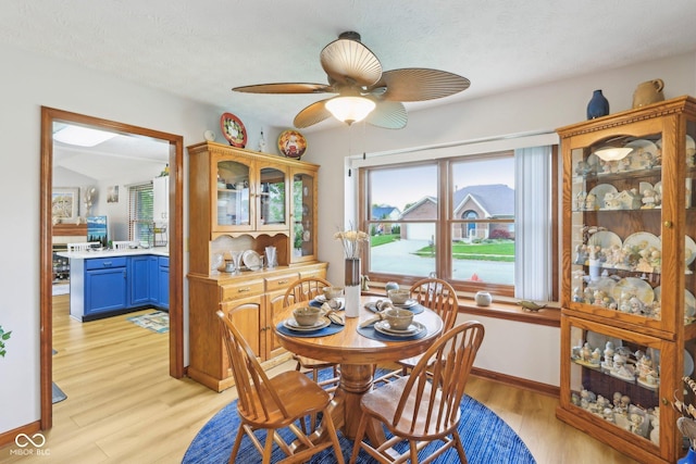 dining space featuring light wood-type flooring, baseboards, and ceiling fan