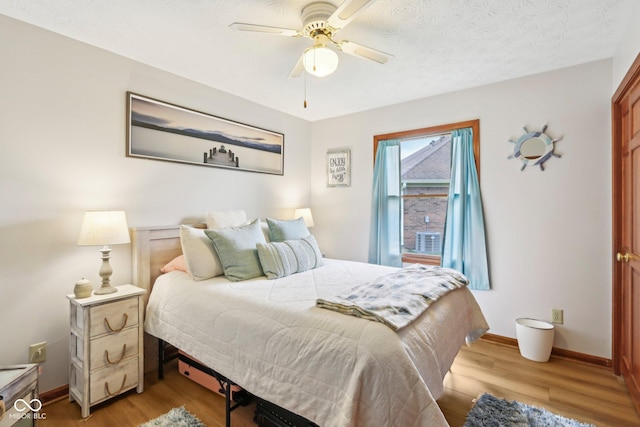 bedroom featuring baseboards, light wood-style flooring, and a ceiling fan