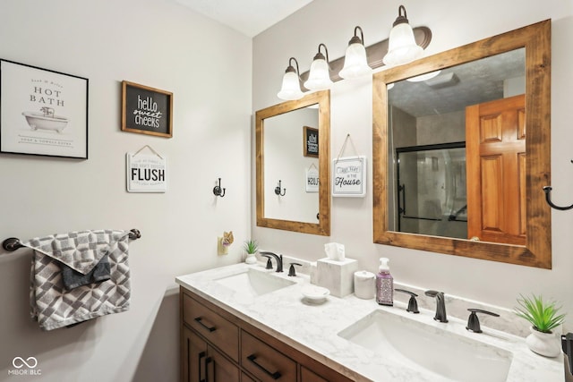 full bathroom with double vanity, a stall shower, and a sink