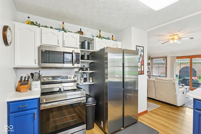 kitchen featuring blue cabinets, light wood-style flooring, white cabinets, and appliances with stainless steel finishes