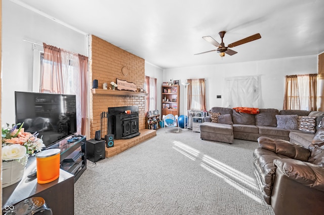 carpeted living room with ceiling fan and a wood stove