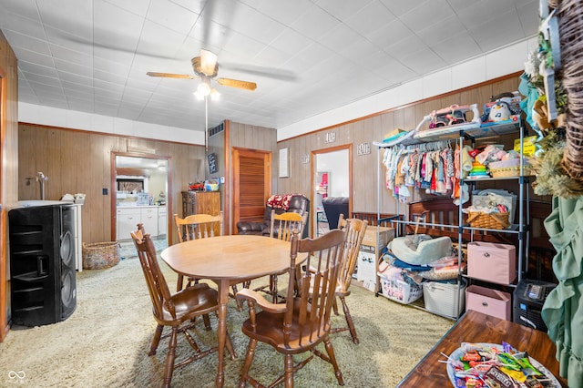 dining space with wood-type flooring, ceiling fan, and wood walls