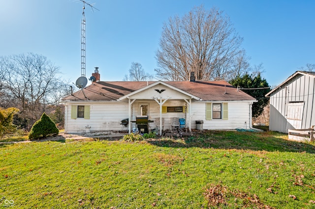 back of property with a shed and a lawn