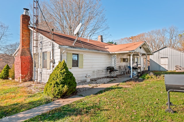 view of front of house with a front lawn and a storage unit