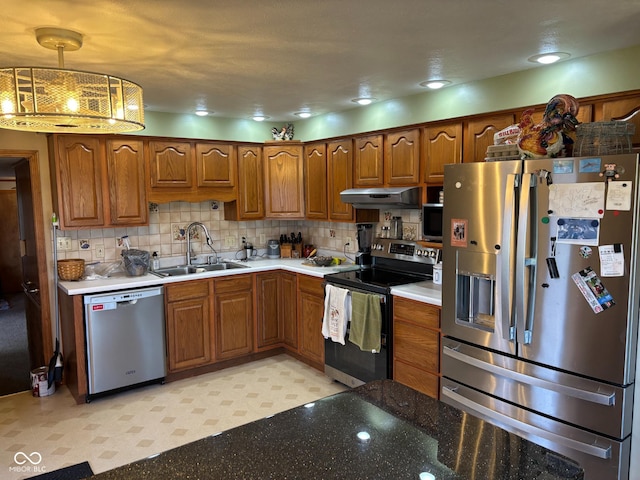 kitchen featuring decorative backsplash, sink, decorative light fixtures, and appliances with stainless steel finishes