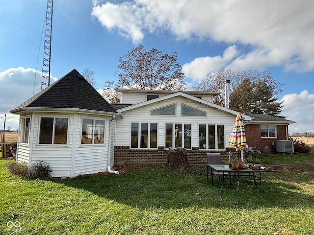 back of property with central air condition unit and a yard