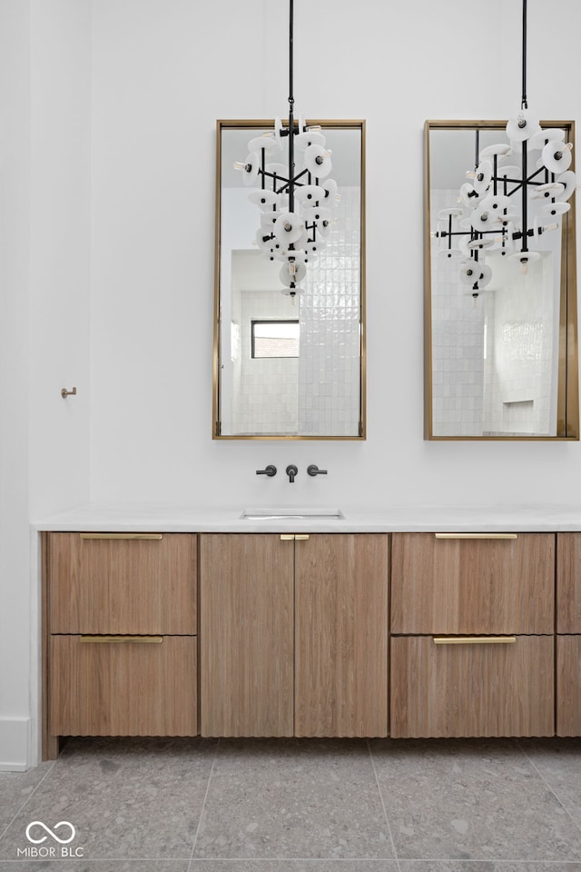 bathroom with tile patterned flooring, vanity, and an inviting chandelier