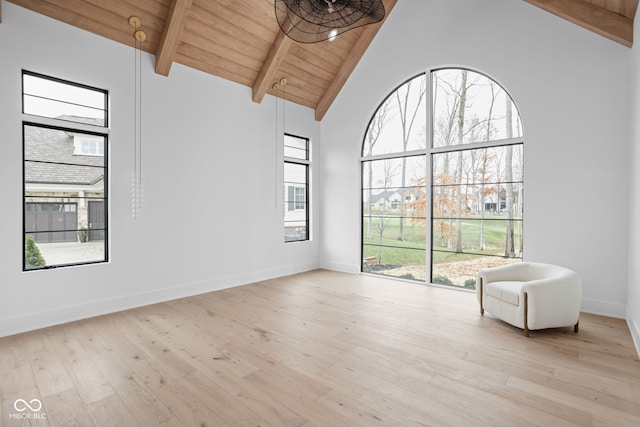 unfurnished room featuring beamed ceiling, light hardwood / wood-style floors, a healthy amount of sunlight, and wooden ceiling