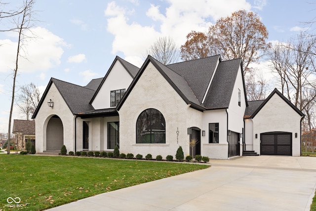 french provincial home featuring a garage and a front lawn