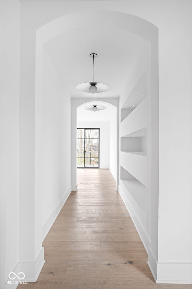 hall with light hardwood / wood-style flooring and built in features