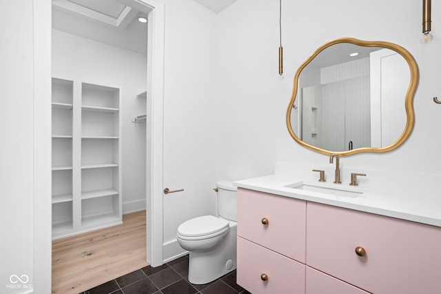 bathroom with vanity, toilet, wood-type flooring, and walk in shower