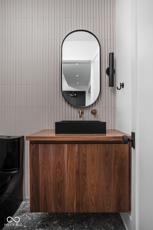 bathroom with vanity and tile walls