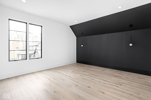 bonus room with vaulted ceiling and light wood-type flooring