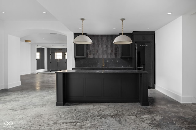 kitchen featuring pendant lighting, decorative backsplash, and a kitchen island