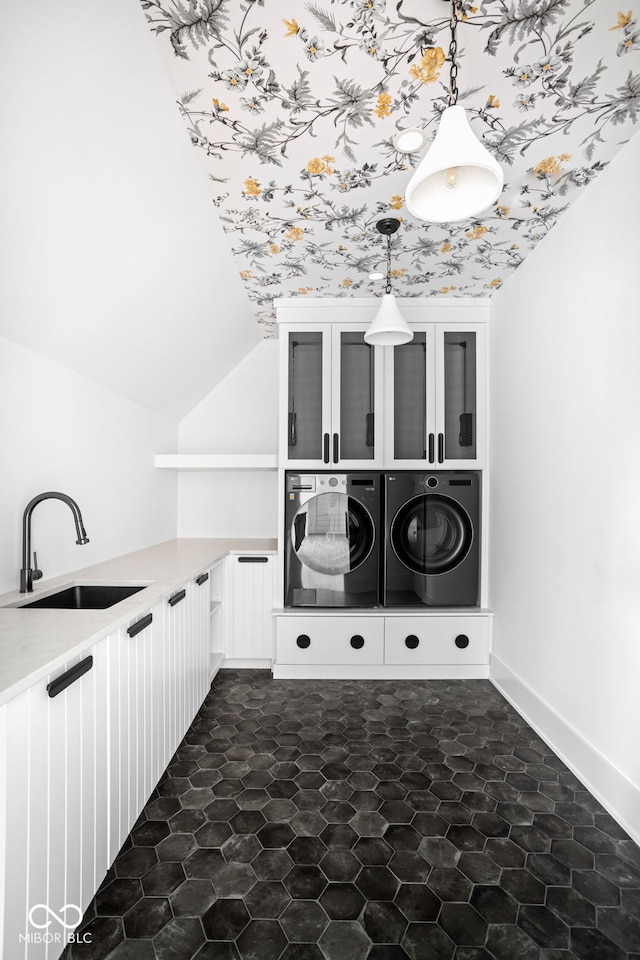 laundry room with washing machine and clothes dryer, sink, and cabinets