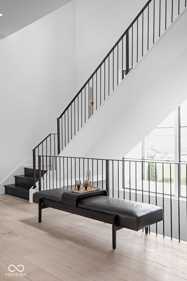 stairway with a towering ceiling and wood-type flooring