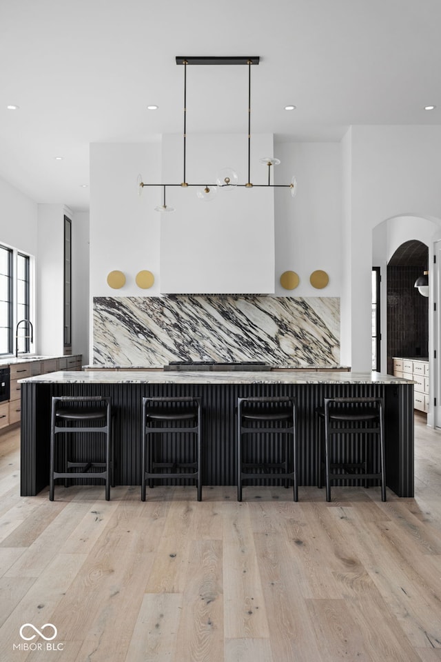 kitchen with backsplash, sink, and light wood-type flooring