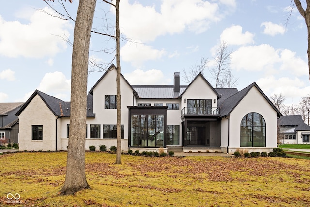 rear view of house featuring a balcony and a sunroom