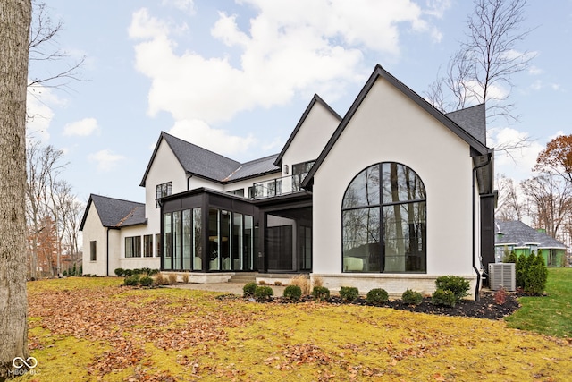 back of property featuring a sunroom, a balcony, and cooling unit