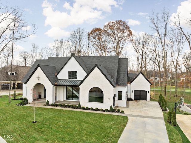 french country style house featuring a front lawn and a garage