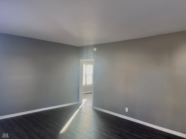 empty room with dark hardwood / wood-style flooring