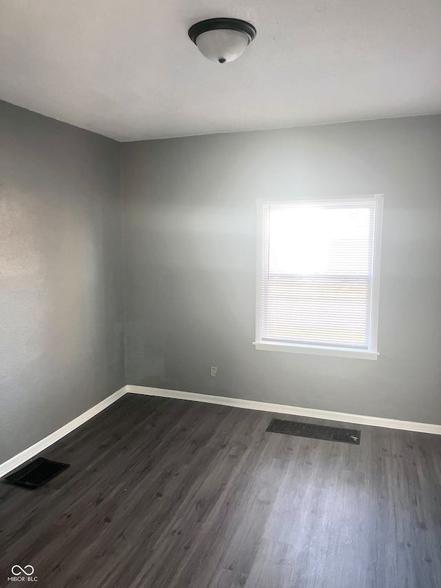 unfurnished room featuring dark wood-type flooring