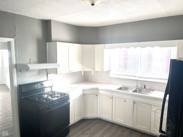 kitchen featuring white cabinets, black gas stove, dark wood-type flooring, and sink