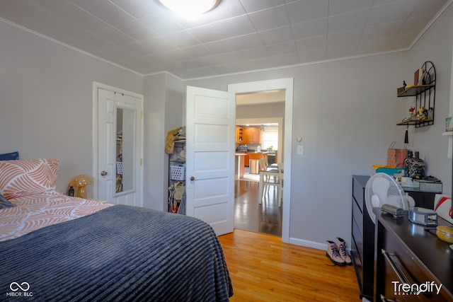 bedroom featuring light wood-type flooring and crown molding