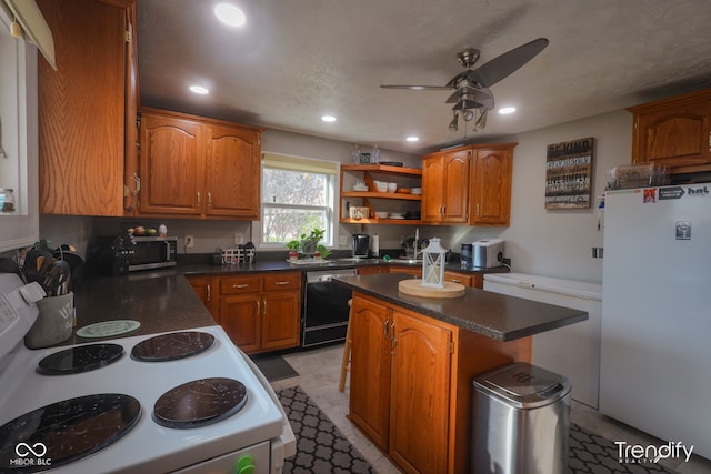 kitchen with a center island, white appliances, and ceiling fan