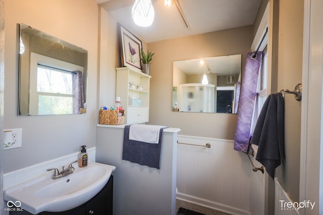 bathroom featuring a shower with door and vanity