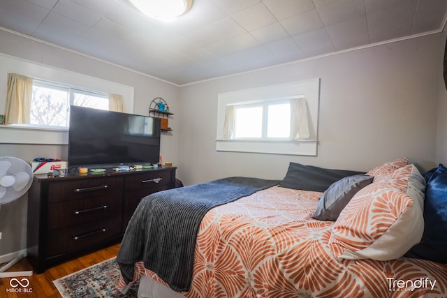 bedroom with hardwood / wood-style flooring and ornamental molding