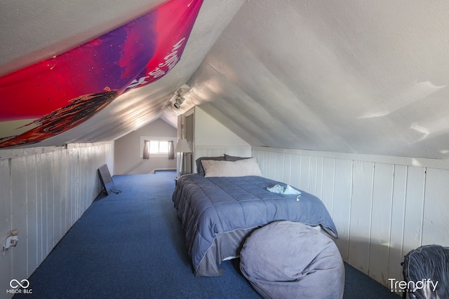 carpeted bedroom with wood walls, a textured ceiling, and lofted ceiling