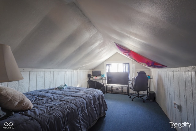 bedroom with wooden walls, a textured ceiling, lofted ceiling, and carpet