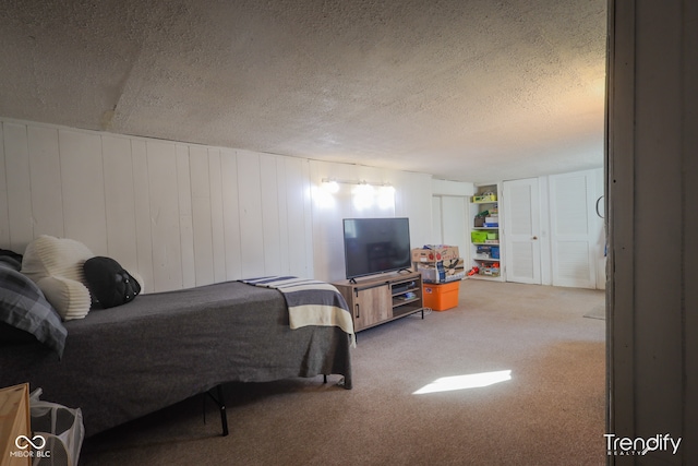 carpeted bedroom with wood walls and a textured ceiling