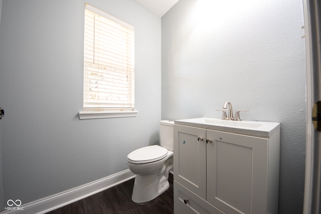 bathroom with hardwood / wood-style flooring, vanity, and toilet