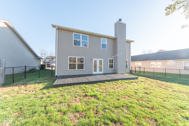 back of property featuring a lawn, a wooden deck, and french doors