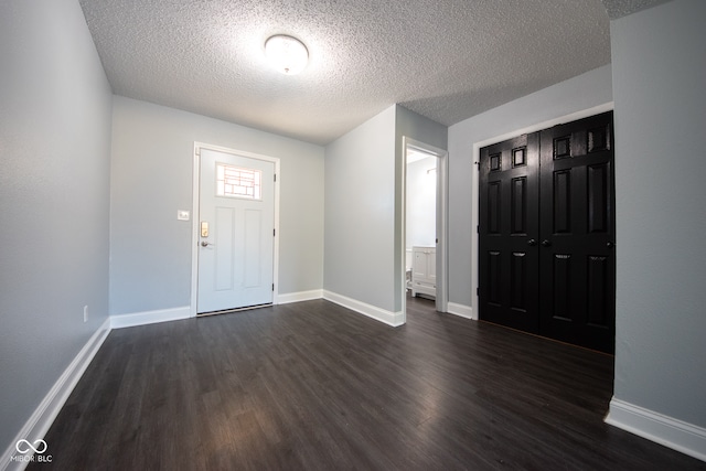 entrance foyer featuring dark wood-type flooring and a textured ceiling