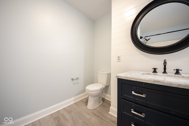 bathroom featuring toilet, vanity, and hardwood / wood-style flooring