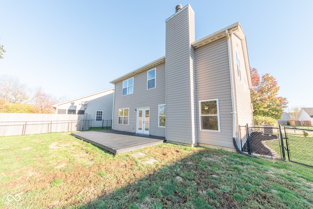 rear view of house featuring a yard and a wooden deck