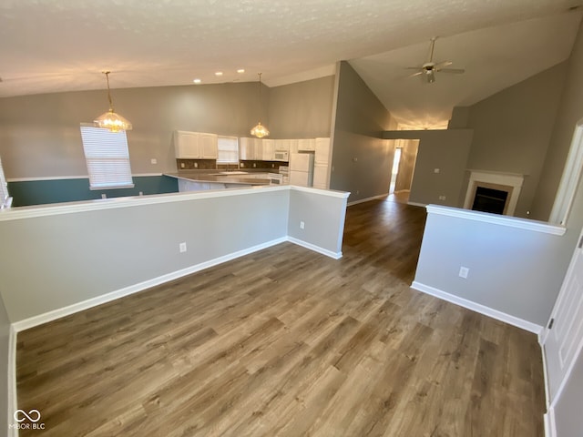 kitchen featuring white appliances, pendant lighting, hardwood / wood-style floors, white cabinets, and kitchen peninsula